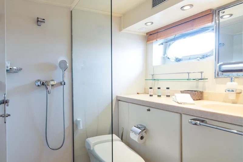 Anonymous Yacht Photos Pics Luxurious yacht bathroom with shower, vanity, and porthole window, Hellenic Shipyards Custom 1981.