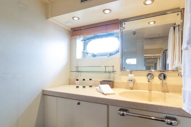 Anonymous Yacht Photos Pics Luxurious yacht bathroom with porthole, mirror, and toiletries, Hellenic Shipyards Custom 1981 model.