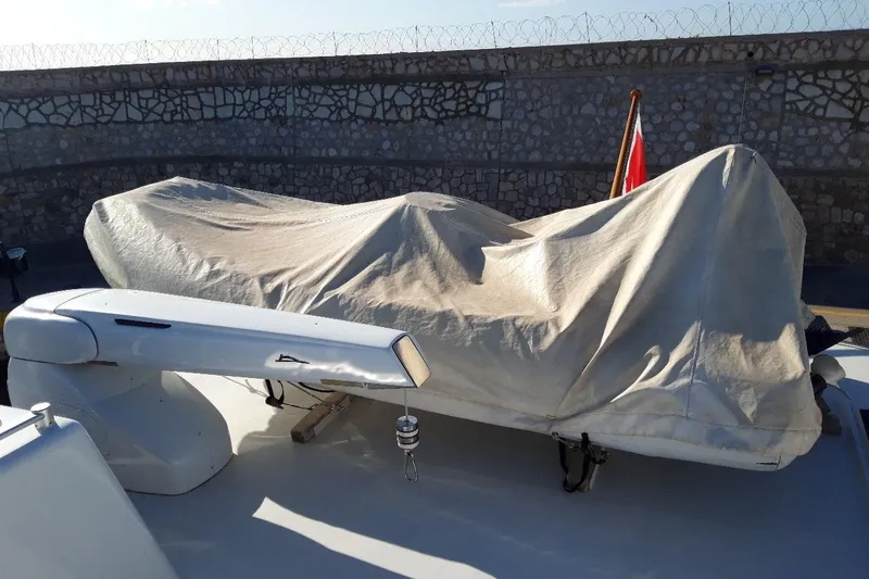 Anonymous Yacht Photos Pics Covered boat on deck, Hellenic Shipyards Custom model, 1981, with stone wall background.