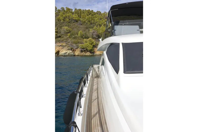  Yacht Photos Pics 2004 Ferretti Yachts 680 cruising near a scenic coastline with lush greenery.