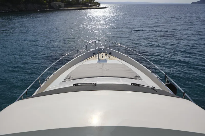  Yacht Photos Pics Bow view of 2004 Ferretti Yachts 680 on calm sea, sun reflecting on water.