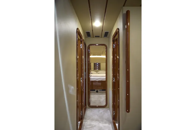  Yacht Photos Pics Narrow hallway inside 2004 Ferretti Yachts 680, featuring polished wood doors and soft lighting.