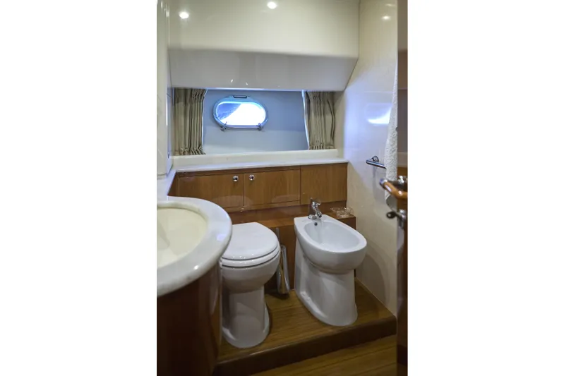  Yacht Photos Pics Luxurious bathroom in 2004 Ferretti Yachts 680, featuring modern fixtures and porthole window.