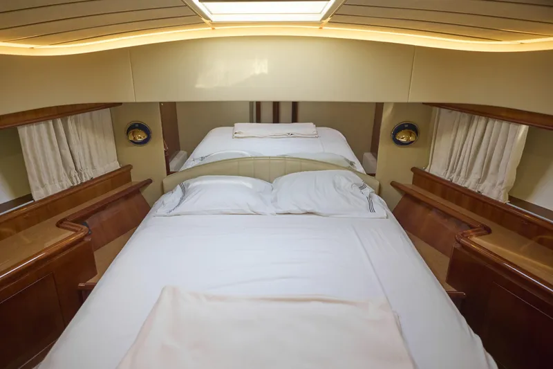  Yacht Photos Pics Luxurious bedroom interior of 2004 Ferretti Yachts 680 with elegant wood finishes.