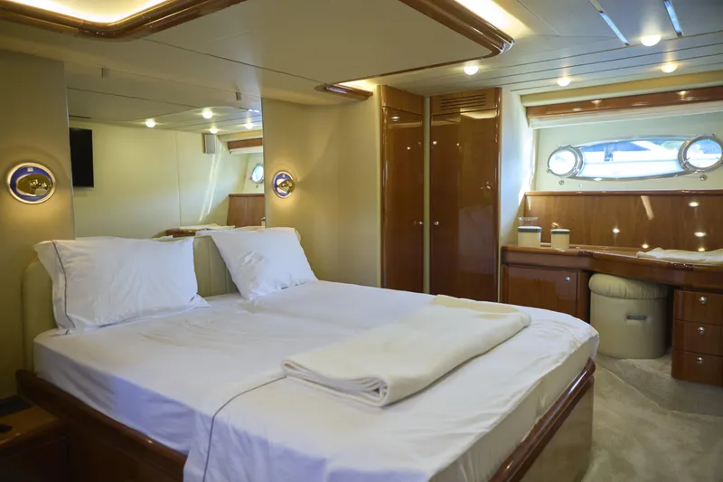  Yacht Photos Pics Luxurious bedroom interior of 2004 Ferretti Yachts 680 with elegant wood finishes.