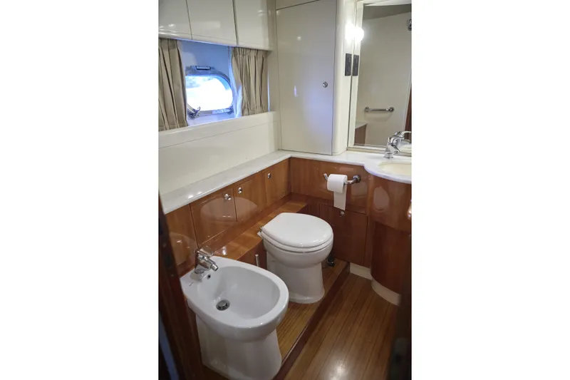  Yacht Photos Pics Luxurious bathroom in 2004 Ferretti Yachts 680, featuring wood accents and modern fixtures.