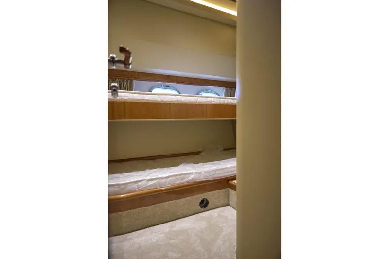  Yacht Photos Pics Bunk beds in 2004 Ferretti Yachts 680 cabin, featuring wooden accents and porthole window.
