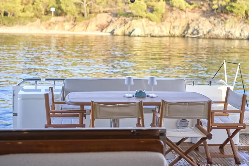  Yacht Photos Pics Outdoor dining area on 2004 Ferretti Yachts 680, overlooking serene waters and lush shoreline.