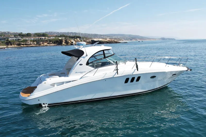 Knock On Wood Yacht Photos Pics 2008 Sea Ray 38 Sundancer yacht cruising on a sunny day near rocky coastline.