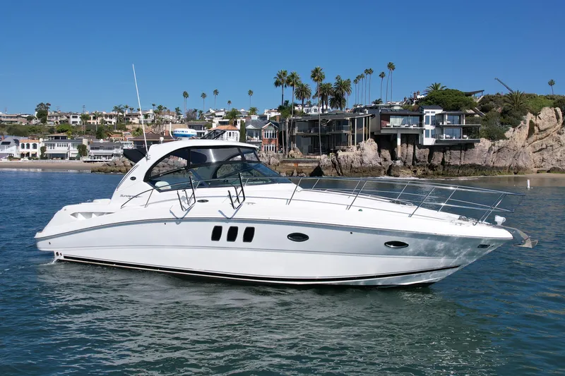 Knock On Wood Yacht Photos Pics 2008 Sea Ray 38 Sundancer yacht cruising near coastal homes under clear blue skies.