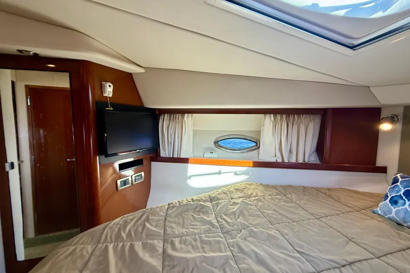 Knock On Wood Yacht Photos Pics Interior cabin of 2008 Sea Ray 38 Sundancer with bed, TV, and porthole window.