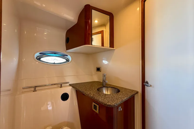 Knock On Wood Yacht Photos Pics 2008 Sea Ray 38 Sundancer bathroom with sink, mirror, and porthole window.