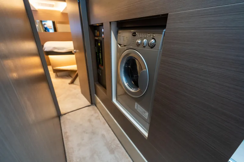 The Office Yacht Photos Pics Laundry area inside 2021 Leopard 53 Powercat yacht, featuring modern washing machine.