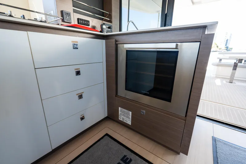 The Office Yacht Photos Pics Modern kitchen area on a 2021 Leopard 53 Powercat yacht, featuring sleek cabinetry and an oven.