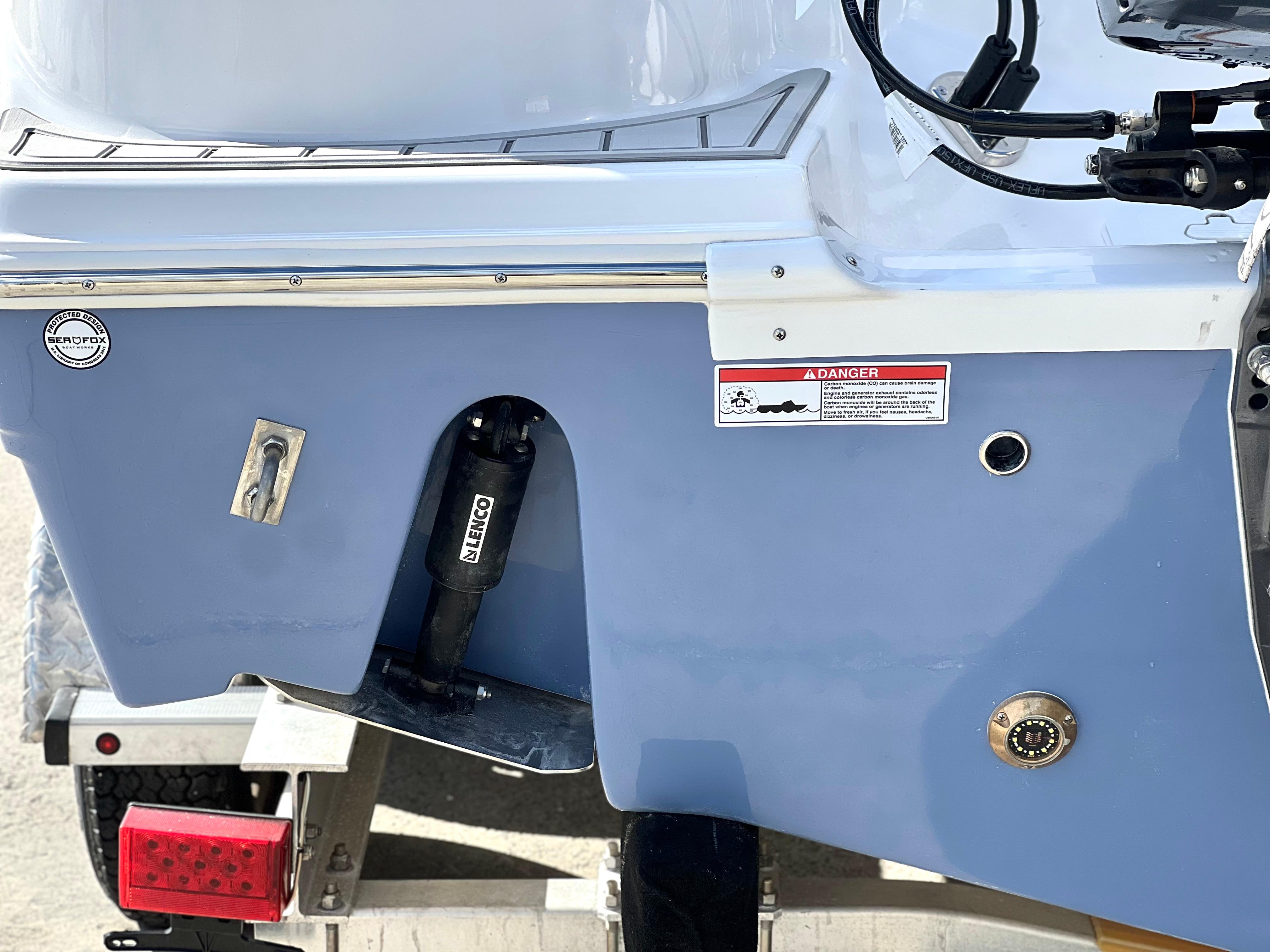2025 Sea Fox 248 Side Console boat stern with trailer and warning label.
