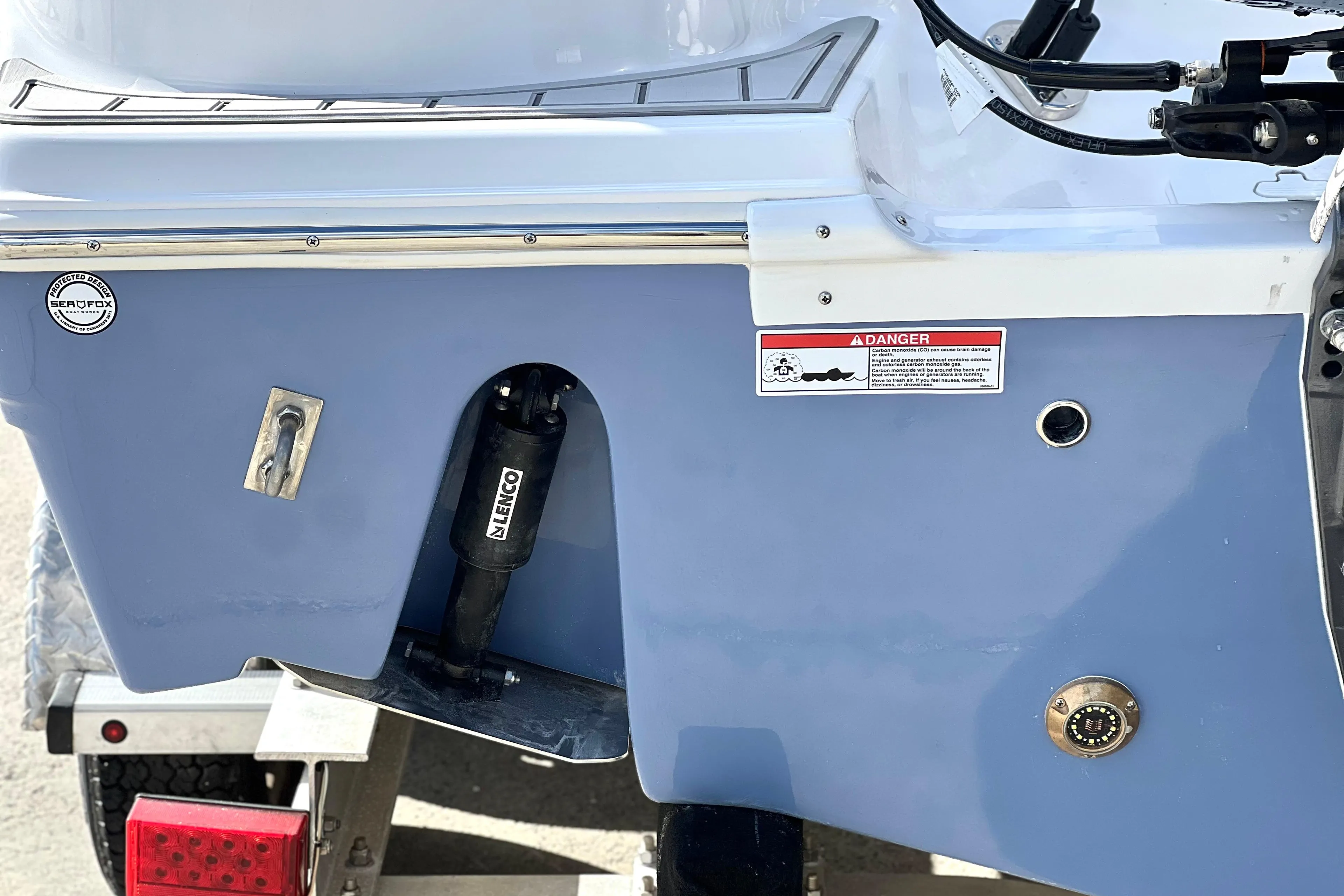 2025 Sea Fox 248 Side Console boat stern with trailer and warning label.