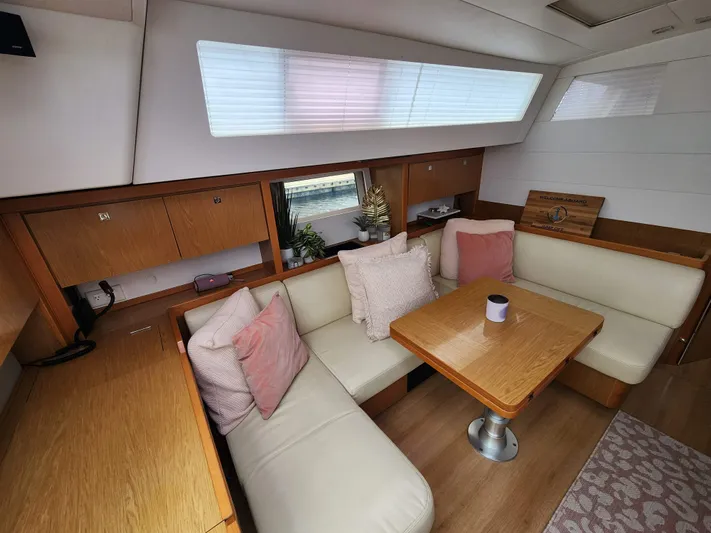Jump Off Yacht Photos Pics Interior of 2011 Beneteau Sense 50 yacht with cozy seating and wooden table.