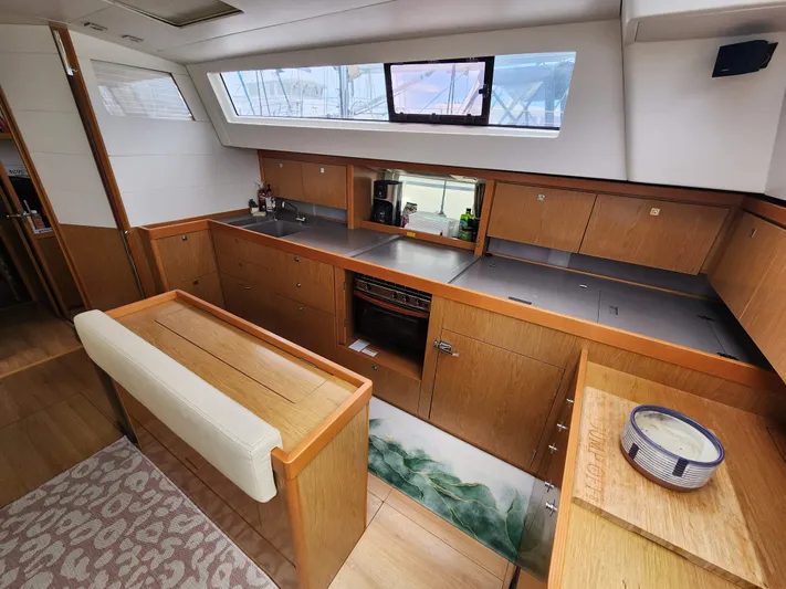 Jump Off Yacht Photos Pics Interior of 2011 Beneteau Sense 50 yacht with modern kitchen and wooden cabinetry.