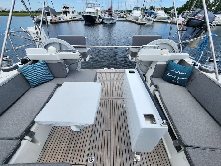 Jump Off Yacht Photos Pics Beneteau Sense 50 yacht deck with seating, table, and marina view.