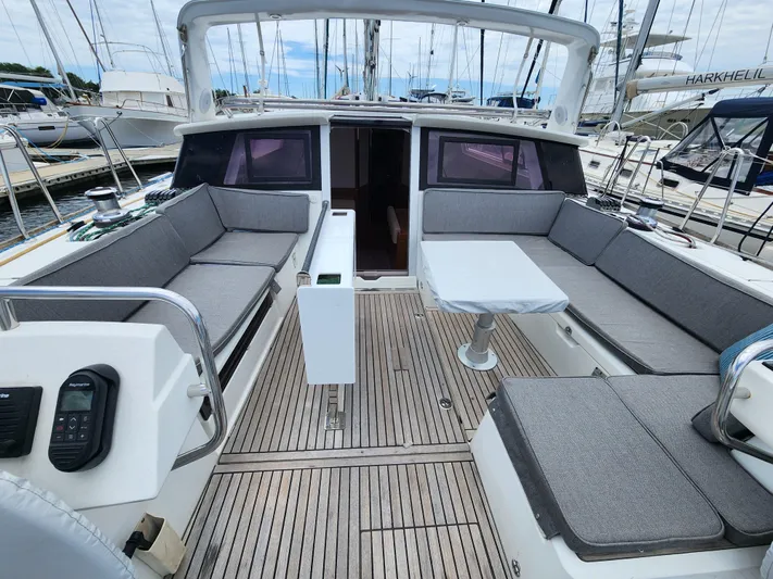 Jump Off Yacht Photos Pics 2011 Beneteau Sense 50 yacht cockpit with spacious seating and table, docked at marina.