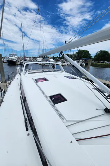 Jump Off Yacht Photos Pics 2011 Beneteau Sense 50 sailboat docked under a blue sky.