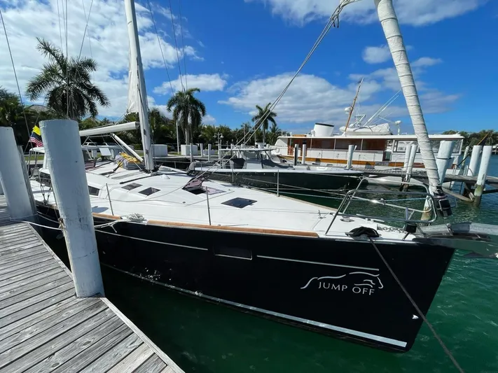 Jump Off Yacht Photos Pics Beneteau Sense 50 sailboat docked, 2011 model, with clear skies and palm trees.