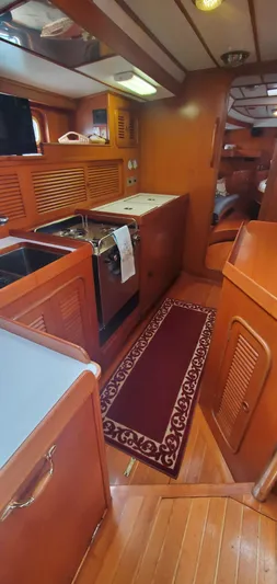Tapestry Yacht Photos Pics Interior of 1989 Tayana 55 yacht with wooden cabinetry and compact kitchen area.