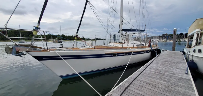 Tapestry Yacht Photos Pics 1989 Tayana 55 sailboat docked at marina, overcast sky, calm waters.