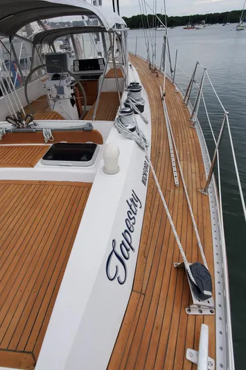 Tapestry Yacht Photos Pics 1989 Tayana 55 sailboat with teak deck, docked in a marina.