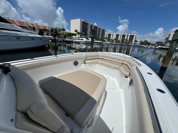  Yacht Photos Pics 2016 Boston Whaler 330 Outrage boat docked in marina, featuring spacious seating area.