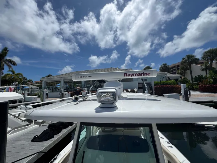  Yacht Photos Pics 2016 Boston Whaler 330 Outrage docked, featuring Raymarine equipment under a partly cloudy sky.