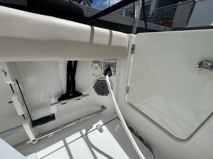 Yacht Photos Pics 2016 Boston Whaler 330 Outrage interior with electrical outlet and storage compartment.