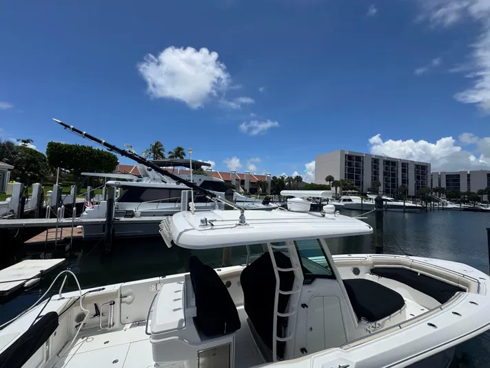  Yacht Photos Pics 2016 Boston Whaler 330 Outrage docked in a marina under a clear blue sky.