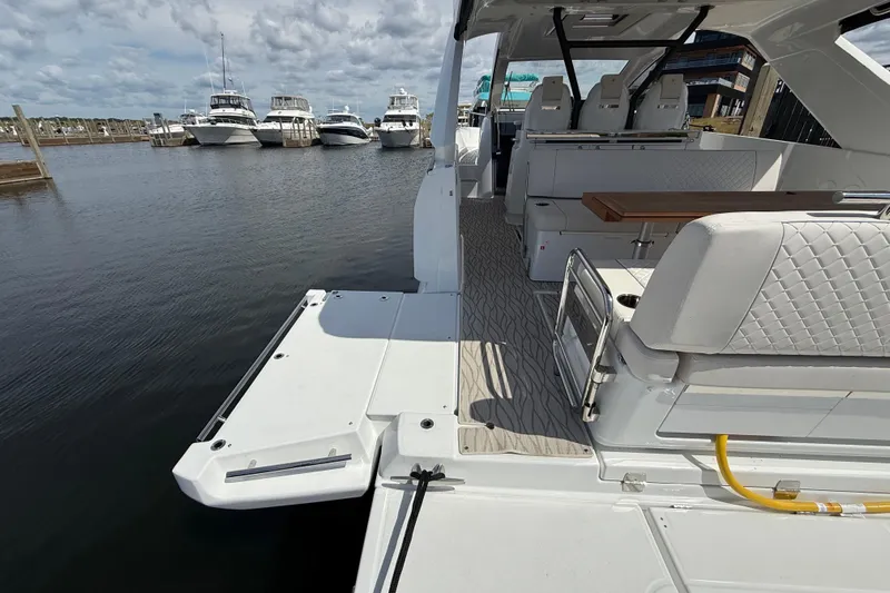  Yacht Photos Pics 2026 Jeanneau DB/37 OB boat interior with seating and table, docked at marina.