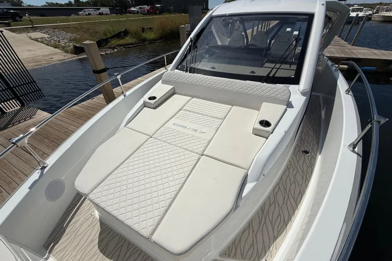  Yacht Photos Pics 2026 Jeanneau DB/37 OB boat with luxurious white seating and sleek design at a dock.