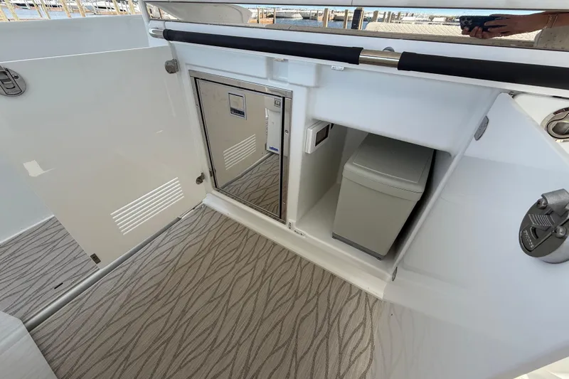  Yacht Photos Pics Interior view of 2026 Jeanneau DB/37 OB boat with storage compartment and mini fridge.