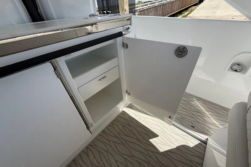  Yacht Photos Pics 2026 Jeanneau DB/37 OB boat interior with open storage cabinet and patterned flooring.