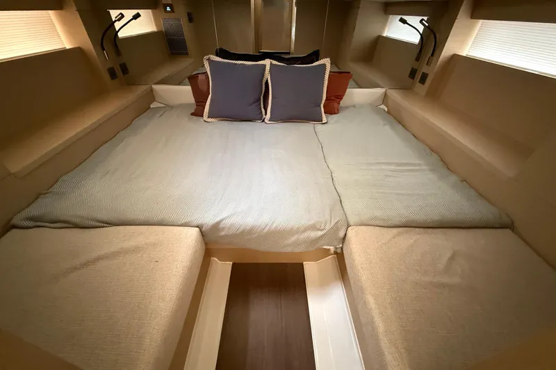  Yacht Photos Pics Luxurious cabin interior of 2026 Jeanneau DB/37 OB with cozy bedding and ambient lighting.