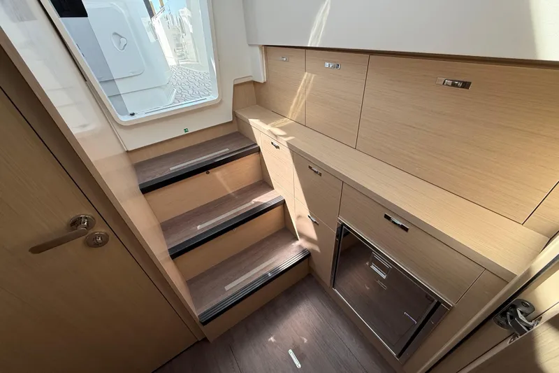  Yacht Photos Pics Interior of 2026 Jeanneau DB/37 OB boat with wooden stairs and storage cabinets.