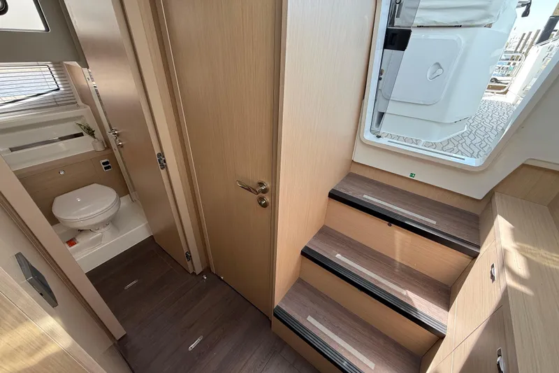  Yacht Photos Pics 2026 Jeanneau DB/37 OB interior with wooden stairs and compact bathroom.