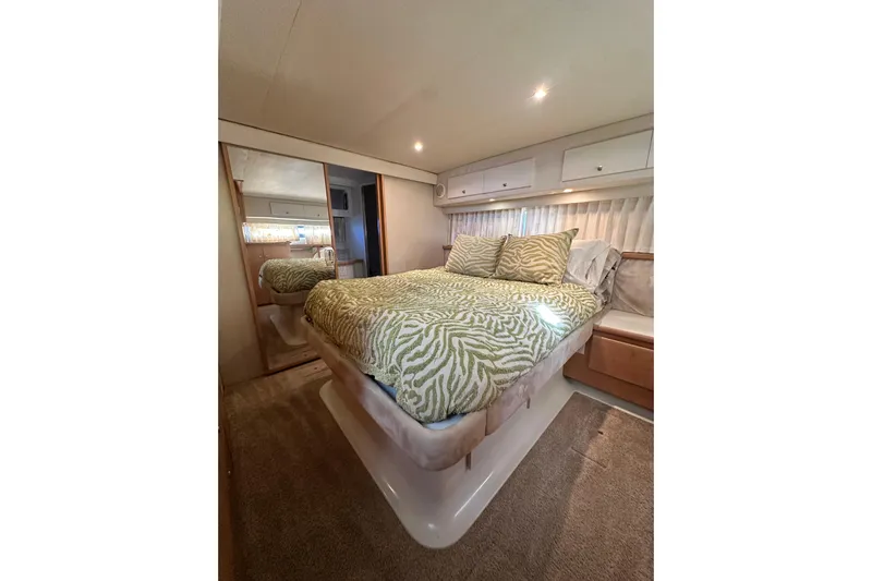 Alyce's Palace II Yacht Photos Pics Luxurious bedroom interior of 1995 Carver 440 Aft Cabin Motor Yacht with patterned bedding.