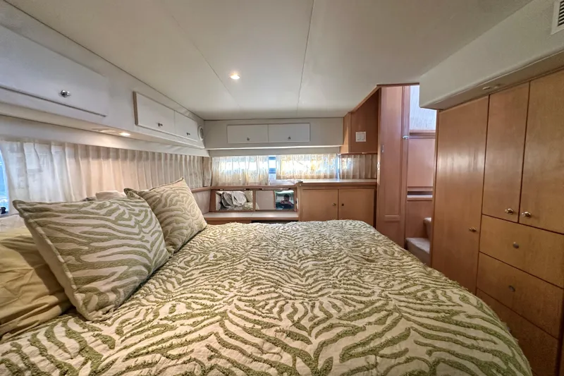 Alyce's Palace II Yacht Photos Pics Luxurious bedroom interior of 1995 Carver 440 Aft Cabin Motor Yacht with patterned bedding.