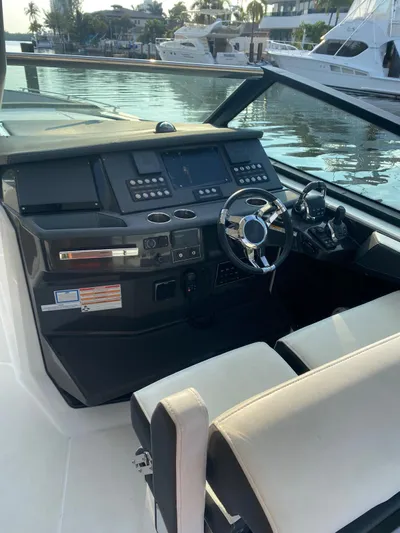  Yacht Photos Pics 2019 Monterey 378 boat cockpit with modern controls and steering, docked by the water.