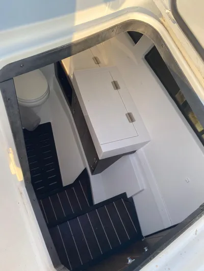  Yacht Photos Pics Interior cabin of 2019 Monterey 378 boat with white cabinetry and black steps.