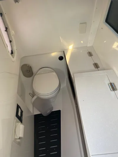  Yacht Photos Pics Compact bathroom in a 2019 Monterey 378 boat, featuring a toilet and storage cabinet.