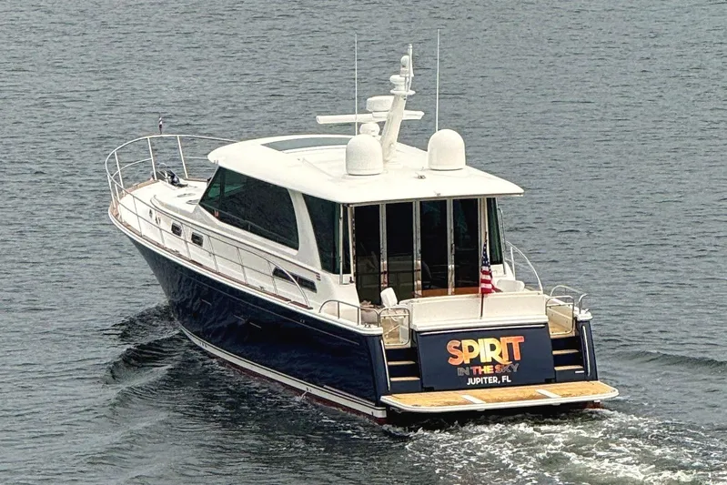  Yacht Photos Pics 2021 Sabre 58 Salon Express yacht cruising on water, rear view.