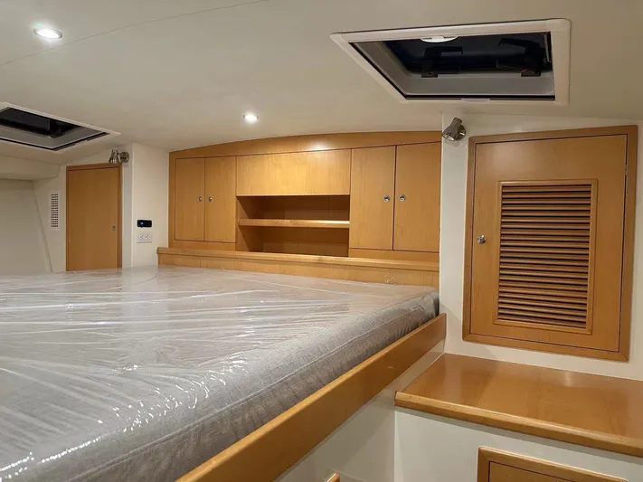  Yacht Photos Pics Luxurious cabin interior of 2025 ArrowCat 420 Flybridge with wooden cabinetry and spacious bed.