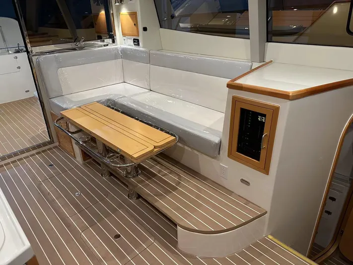  Yacht Photos Pics 2025 ArrowCat 420 Flybridge interior with sleek seating, wooden table, and modern design.