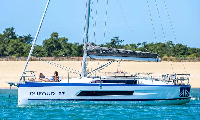  Yacht Photos Pics Manufacturer Provided Image: Dufour 37 sailboat, 2026, on calm water near sandy beach.