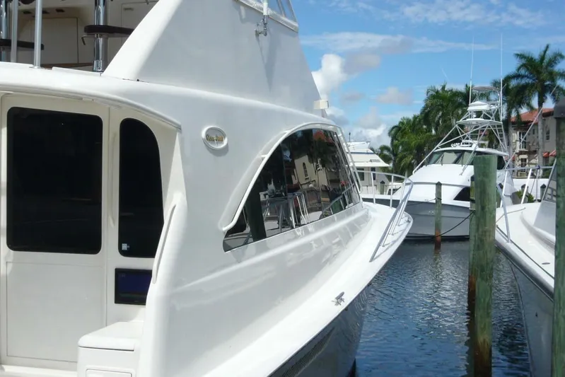 Bella Donna Yacht Photos Pics 1999 Ocean Yachts 56 docked in a marina with palm trees and blue sky.